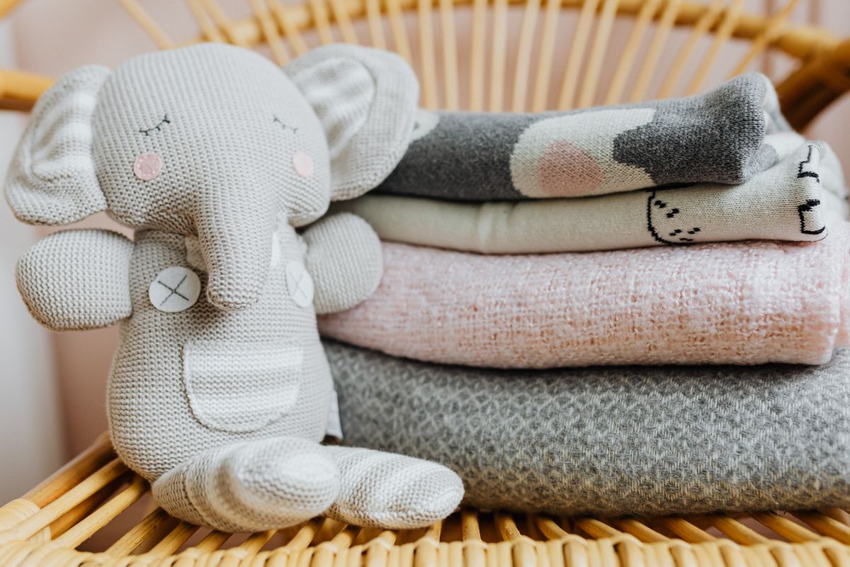A knitted elephant plush in a cozy setting